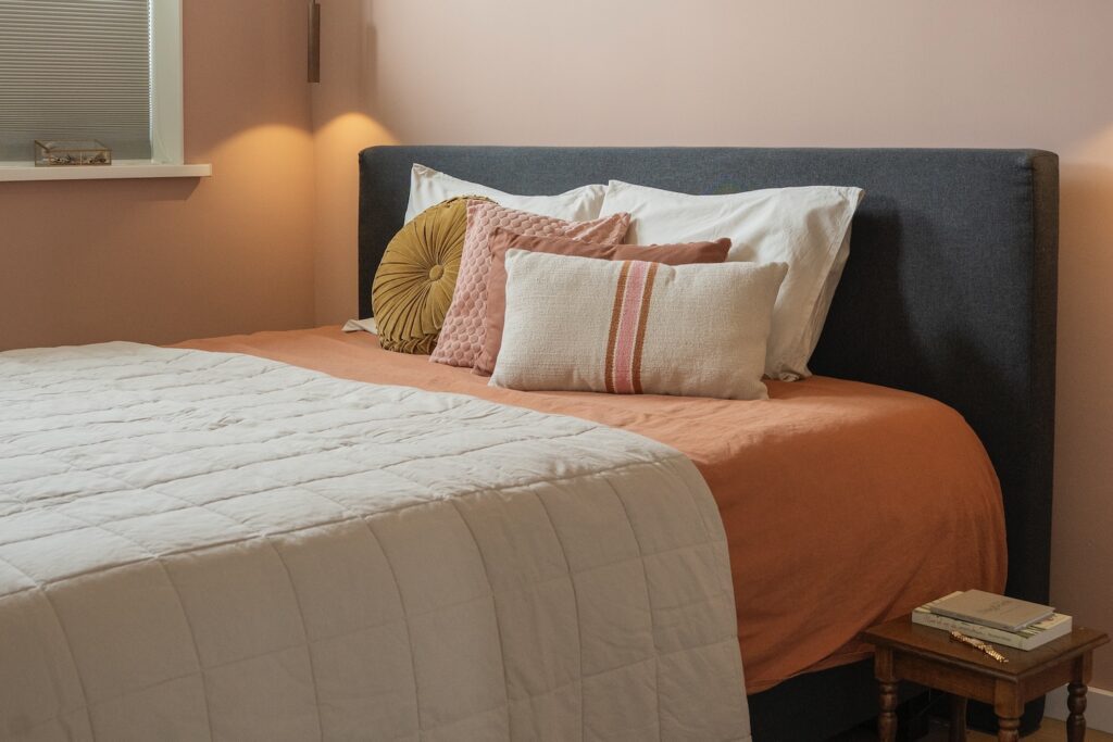 Boho chique slaapkamer met sierkussens in aardetinten op het bed