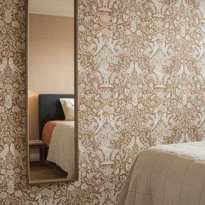 Sfeervolle slaapkamer met bloemen- en vogelbehang in beige en terracotta