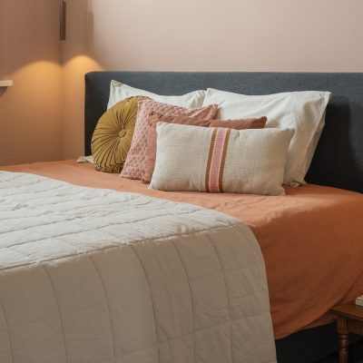 Boho chique slaapkamer met sierkussens in aardetinten op het bed